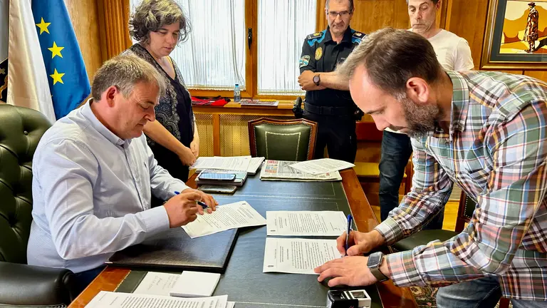 Amador D&iacute;az e Jos&eacute; Manuel Est&eacute;vez, asinando diante dos cabos da Polic&iacute;a Local e da secretaria do Concello